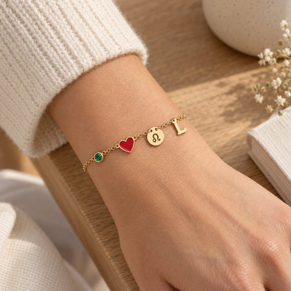 Bracelet Olianne au poignet : pierre verte de mai, cœur rouge, signe Lion et initiale L