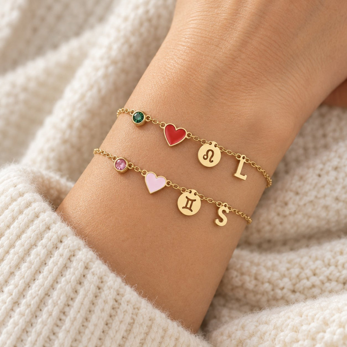 Deux bracelets Olianne superposés au même poignet : initiales L et S, cœurs rouge et rose
